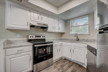 A kitchen with white cabinets and a black stove top oven.
